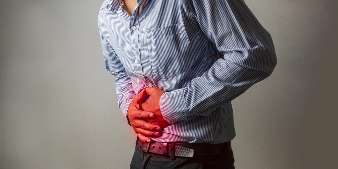 Man grasping stomach in pain