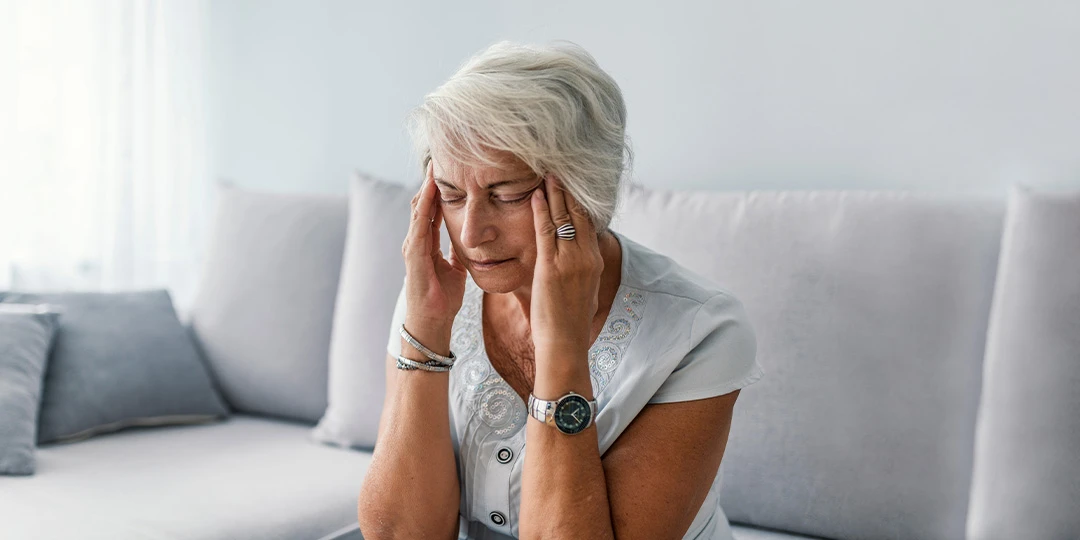 Mature woman appearing stressed holding her head